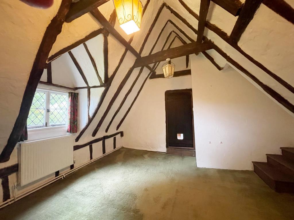 Lot: 31 - A DETACHED THATCHED COTTAGE FOR IMPROVEMENT AND REPAIR - Bedroom 1 with exposed beams and vaulted ceiling